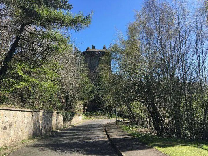 Tree-lined path below Ravenscraig Castle's rounded tower