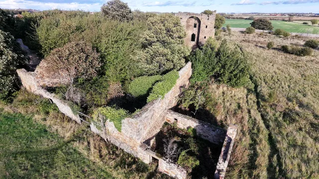Aerial view along Saltcoats Castle's ruined enclosure towards the tower