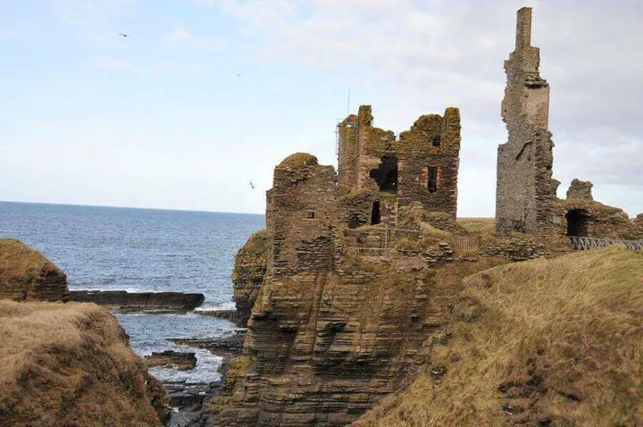 Window openings and a tall chimney above the cliffs at Sinclair Girnigoe Castle