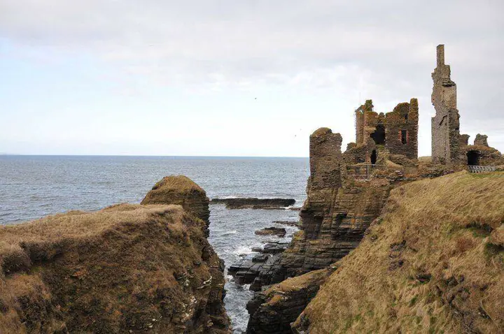 Sinclair Girnigoe Castle across a grass-topped coastal ravine
