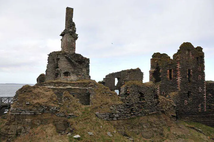 Roofless stone walls and chimney remnant inside Sinclair Girnigoe Castle