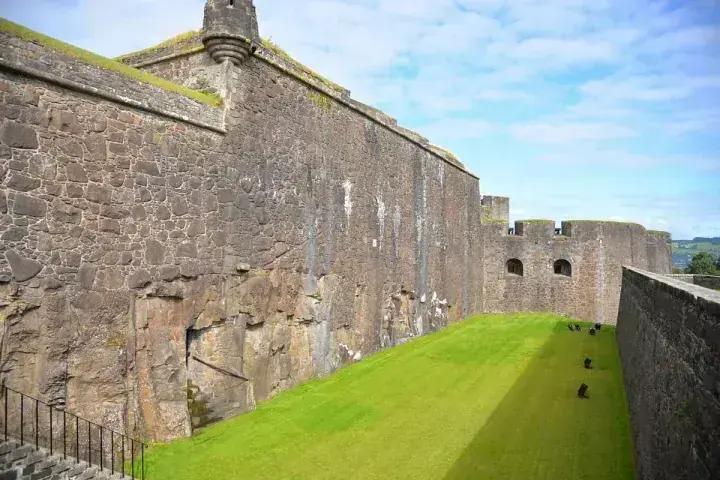 High stone defensive wall beside a narrow lawn at Stirling Castle