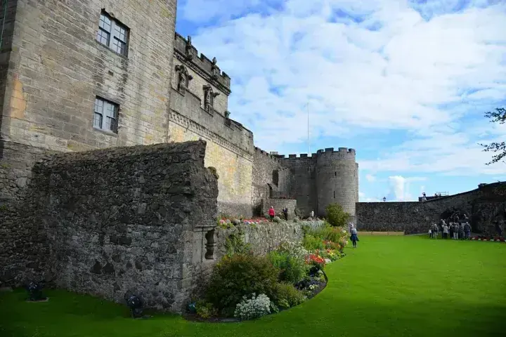 Stirling Castle walls above a lawn bordered by flowering plants