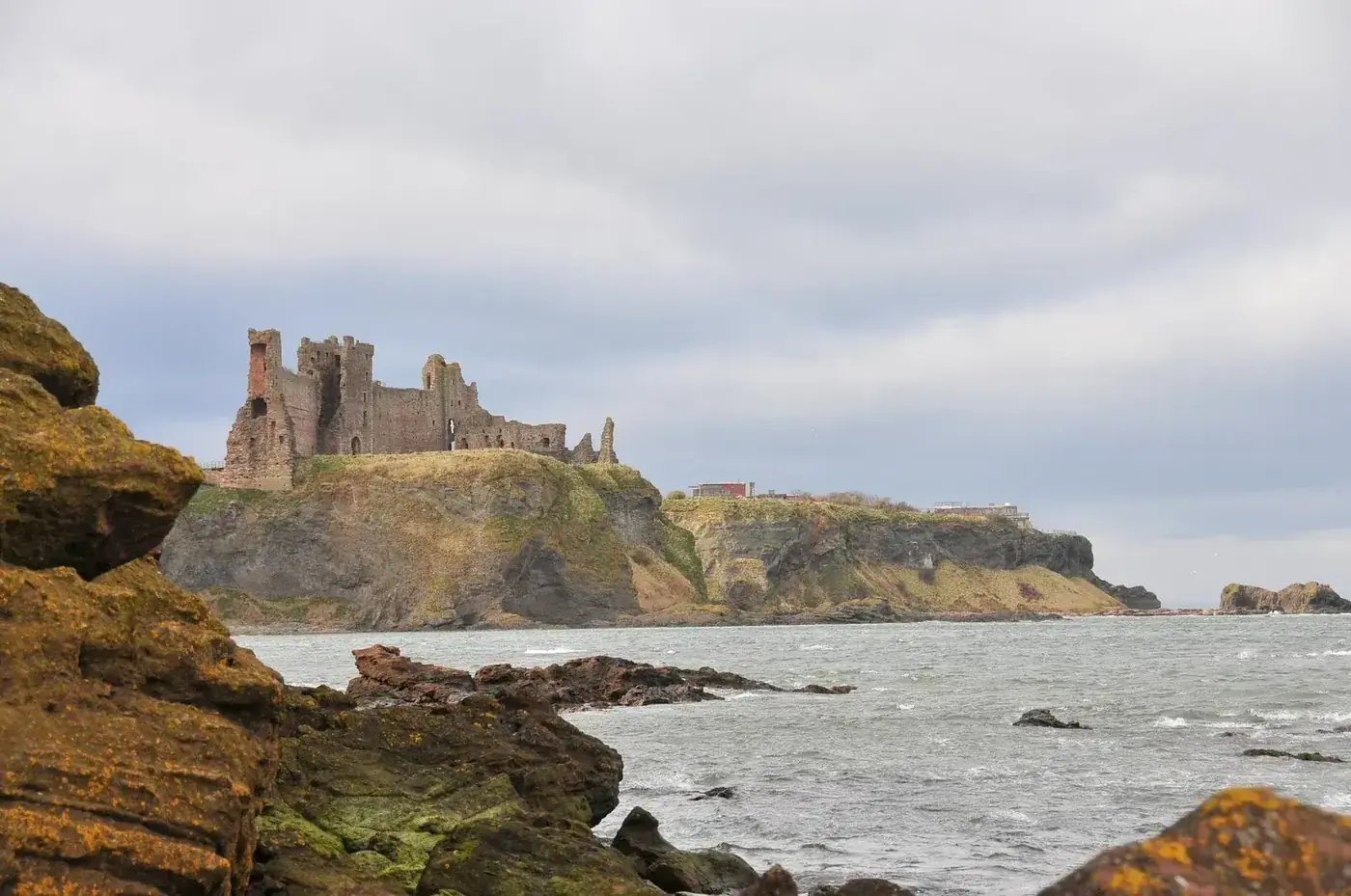 Tantallon Castle on coastal cliffs viewed from a rocky shore