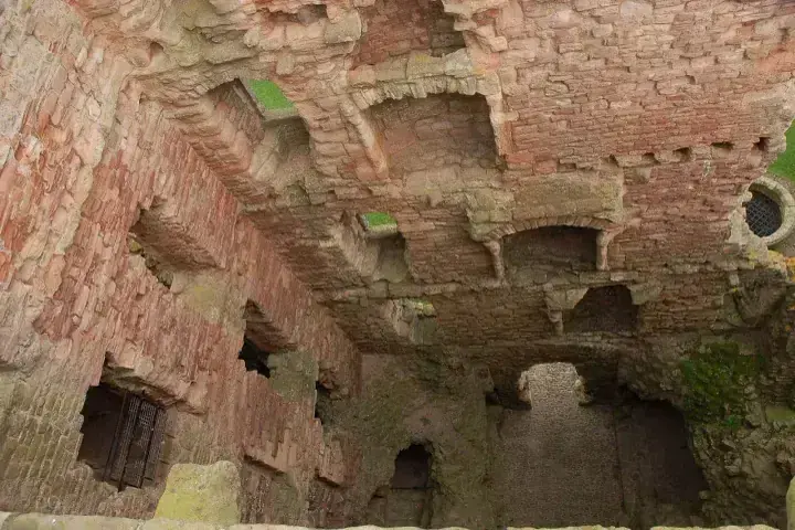 Red stone interior walls of Tantallon Castle with empty window openings