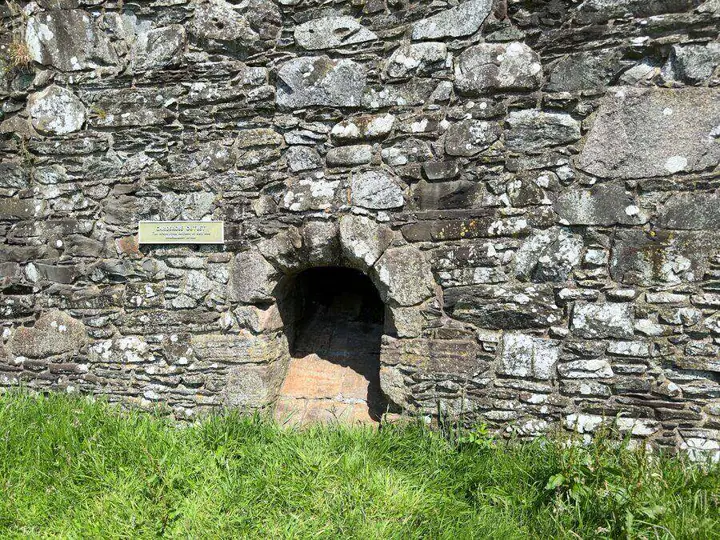 Low arched doorway in the rough stone wall of Threave Castle