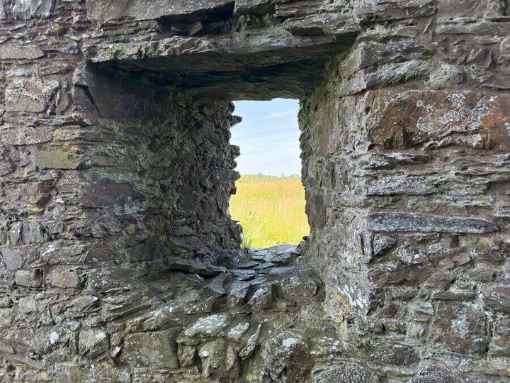 Meadow seen through a small stone window at Threave Castle
