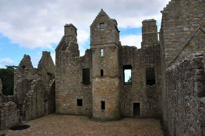 Gravel courtyard and tall central turret within Tolquhon Castle ruins