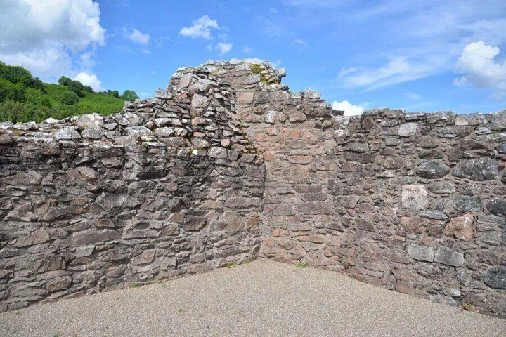 Broken stone walls enclosing a gravel area at Urquhart Castle