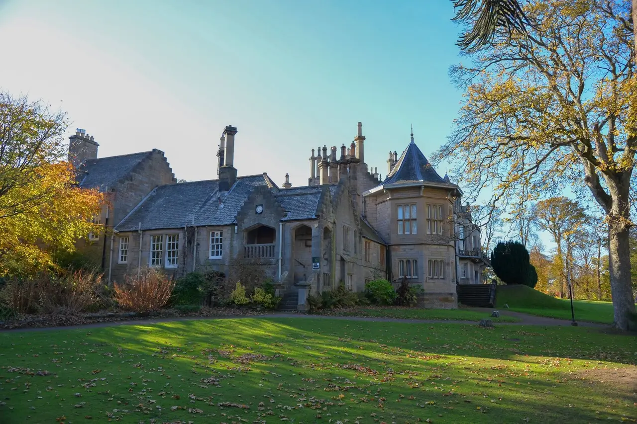 Lauriston Castle garden elevation with a pointed turret roof and autumn foliage